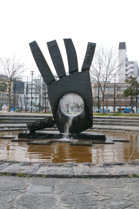 The fountain is flowing through the middle of the hand.